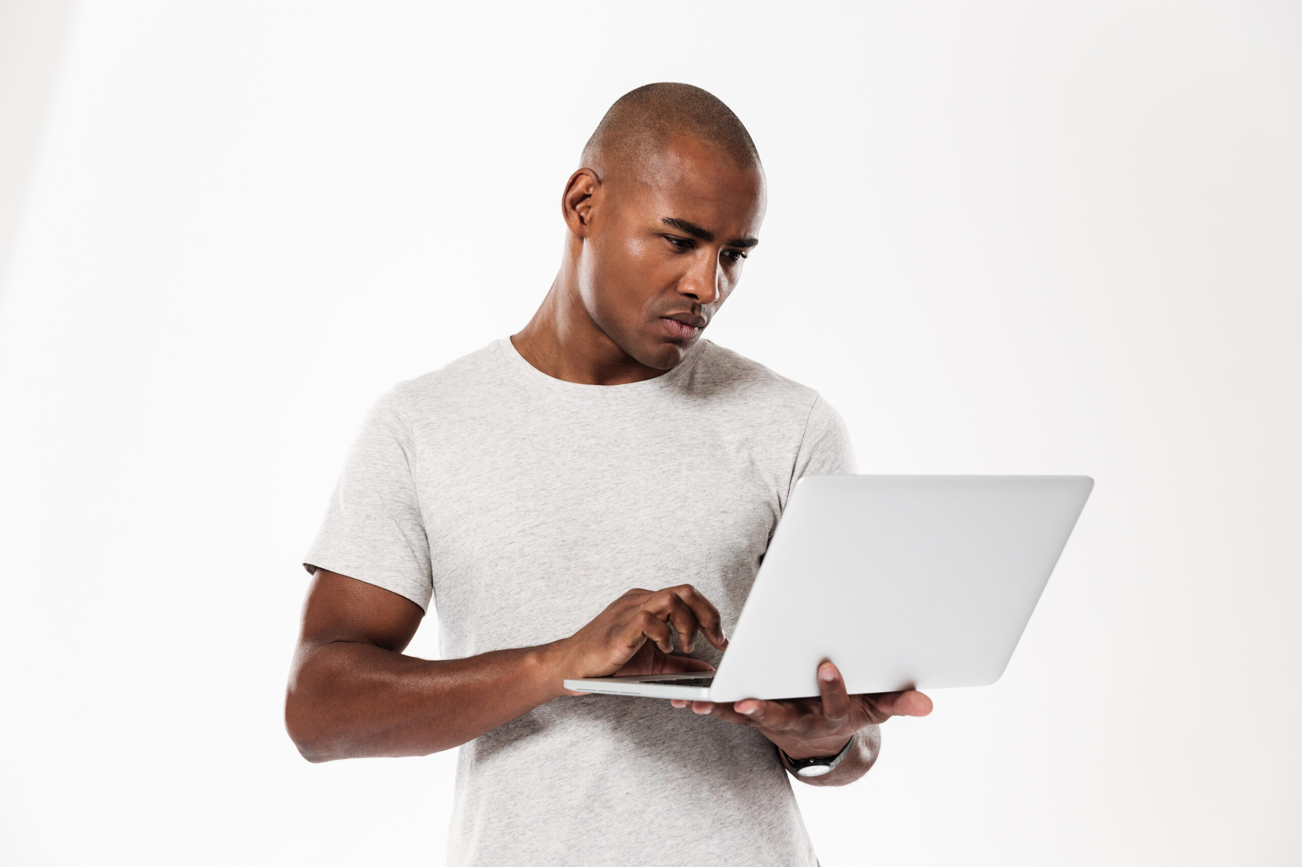 man standing and looking at a laptop